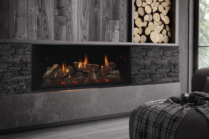 Kozy Heat linear gas fireplace in a dark wood accent wall with firewood storage